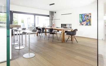 Open kitchen and dining area with oxidatively oiled wooden parquet in the treatment 